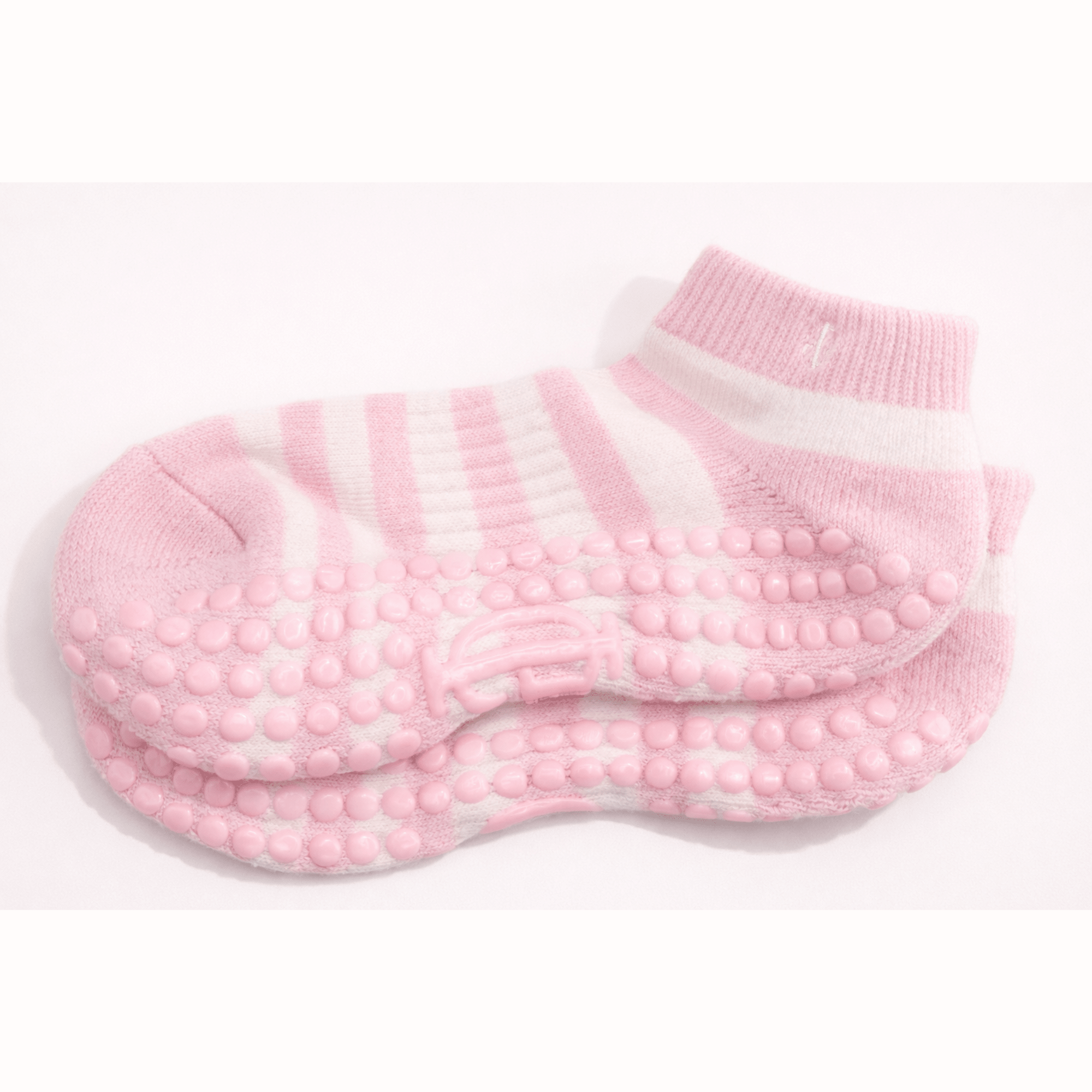 Pair of pink and cream grip pilates socks with textured sole on a white background feminine soft movement