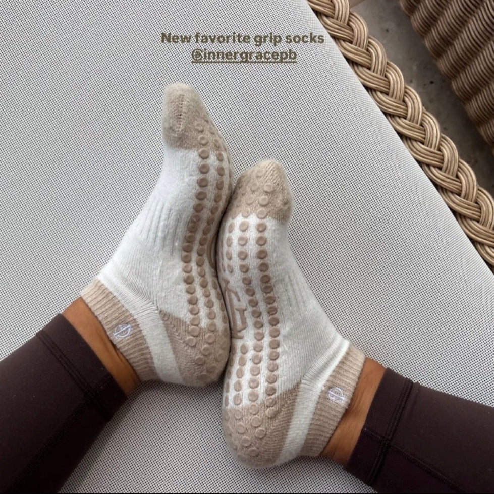 Grip socks with brand tag and packaging on a textured surface