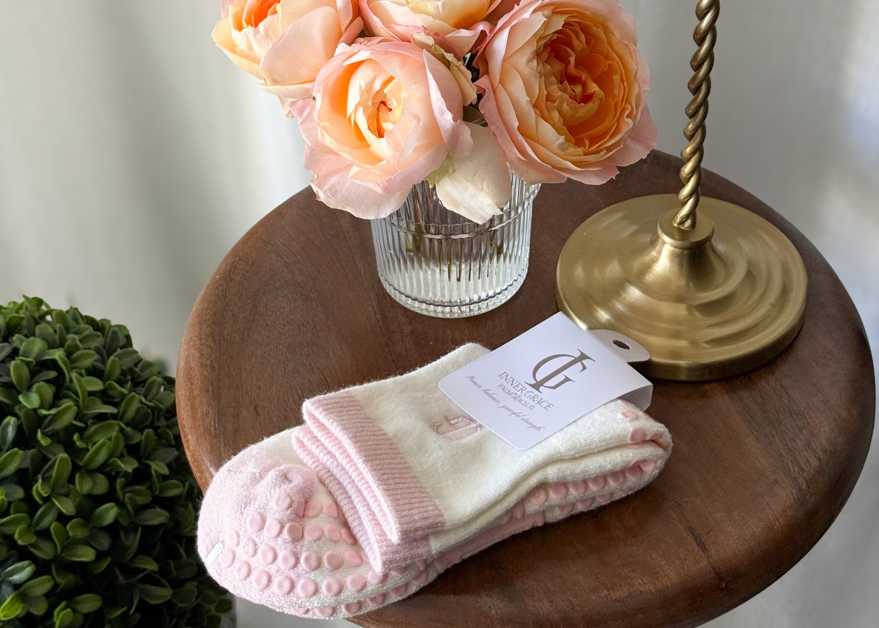 PINK GRIP socks on table with pink flowers and gold lamp 
